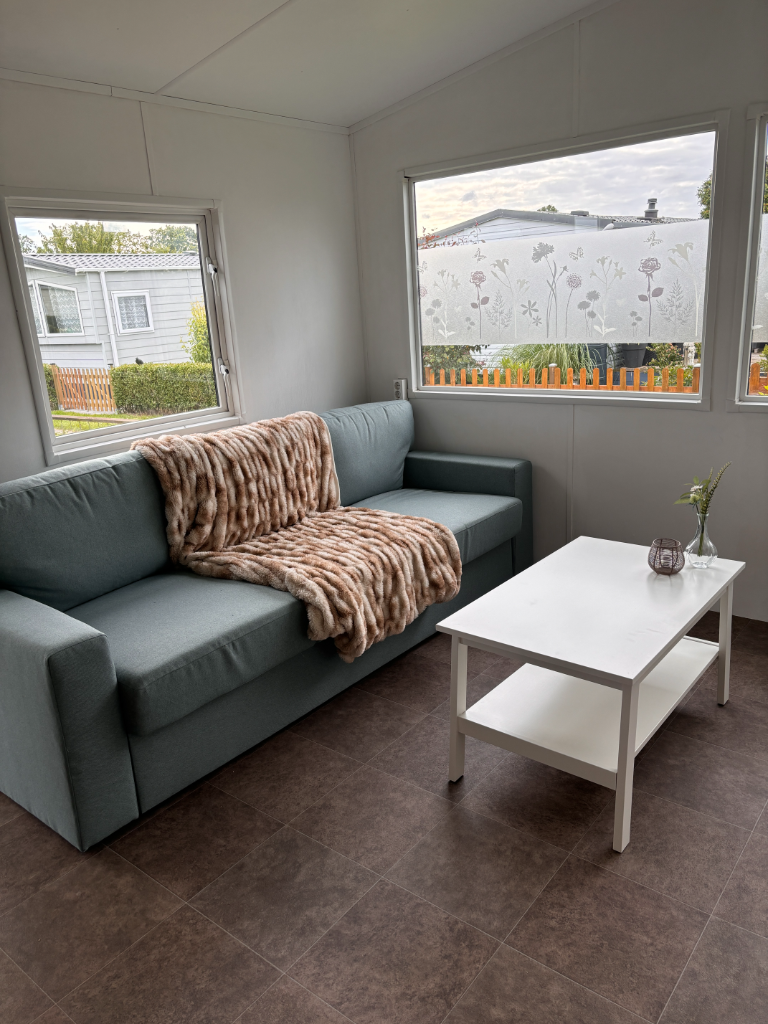 pimpen stacaravan, slaapbank zeeblauw en witte salontafel