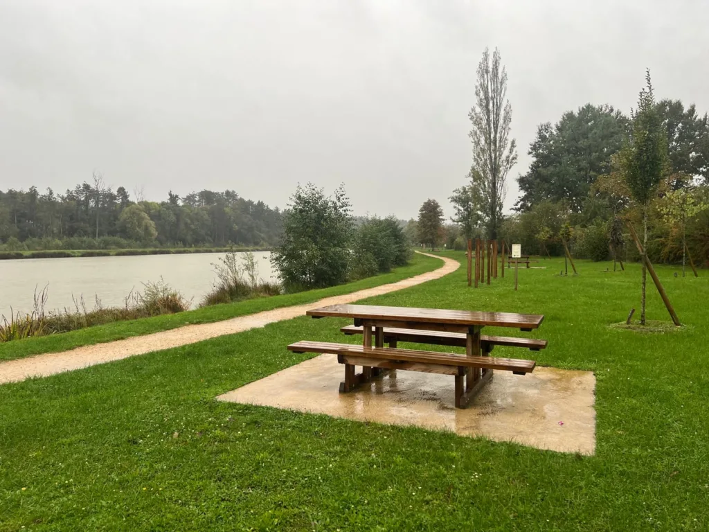 Camperplaats aan een meer, met picknicktafel en bomen